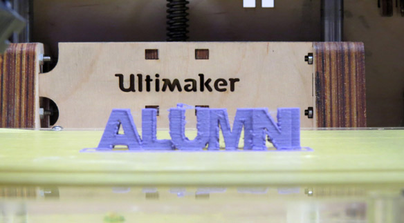 Ein gefrästes Alumni Logo auf einem Tisch